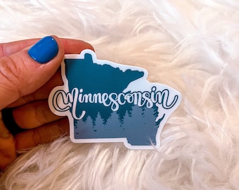 May include: A blue and white sticker of the state of Minnesota with the word "Minnesota" written in white cursive lettering. The sticker has a silhouette of a forest in the bottom of the state.