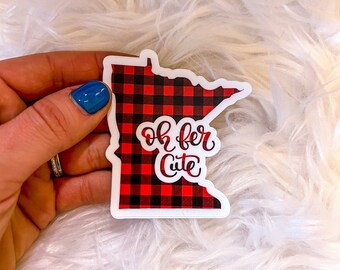 May include: A red and black buffalo plaid Minnesota state outline sticker with the text "Oh for Cute" in white cursive lettering.