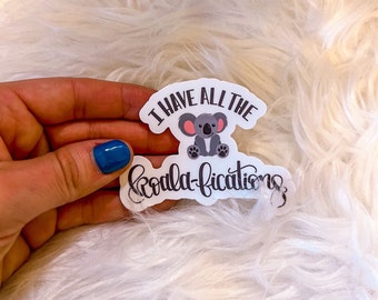 May include: White sticker with a cartoon koala and the text "I have all the koala-fications".