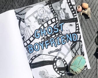 Puede incluir: Un cómic en blanco y negro con el título "Ghost Boyfriend" de Quinn Wilton. La portada presenta una ilustración en blanco y negro de un rostro con una tira de película alrededor.
