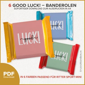 Könnte beinhalten: Eine Auswahl an bunten Schokoriegel-Verpackungen mit dem weißen Aufdruck "good luck!". Die Verpackungen sind in Rosa, Blau, Grün und Gelb gehalten, mit dem Text "6 Good Luck!" oben.