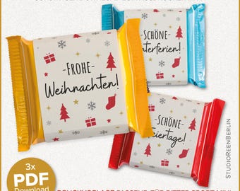 Op de afbeelding: Drie verpakte chocoladerepen met feestelijke kerstontwerpen. De verpakkingen bevatten vakantiegraphics, waaronder kerstbomen, sneeuwvlokken en de tekst "Frohe Weihnachten!" en "Schöne Feiertage!" in het Duits. De repen zitten in gele, blauwe en rode verpakkingen.