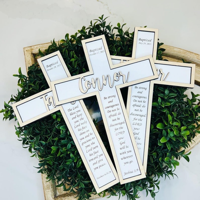 May include: Four wooden crosses with the name "Connor" and the word "Baptized" with dates on each. The crosses have inspirational quotes and bible verses on them.