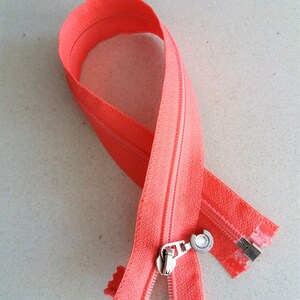 Divisible zipper, made of plastic with metal pulls. Various models.