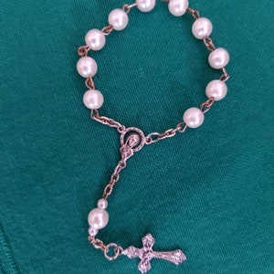 Rosary for prayer in hand with medal and cross. Wooden finger rosary.
