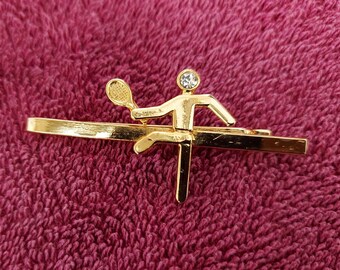 Tie clip with tennis player figure.