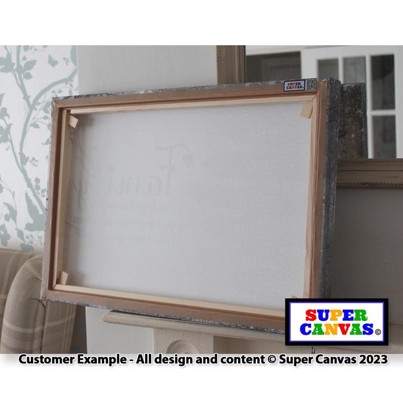 May include: A close-up of a stretched canvas with a wooden frame. The canvas is white and the frame is a light brown color. The text "SUPER CANVAS" is printed in colorful letters on the frame.