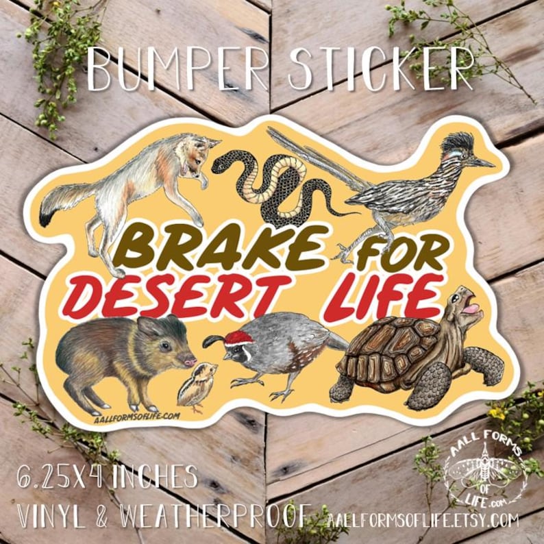 May include: A yellow bumper sticker with the text "BRAKE FOR DESERT LIFE" and illustrations of desert animals. The sticker is 6.25 x 4 inches and made of vinyl. It features a wolf, snake, roadrunner, javelina, quail, and tortoise.