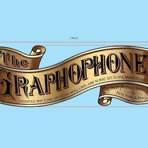 May include: A gold-colored banner with the text "The Graphophone" in black lettering. The banner is curled at the ends and has the text "Patented May 4, 1886. Dec. 27, 1887. April 3, 1888. June 10, 1890. Oct. 15, 1894. March 20, 1897" and "Columbia Phonograph Co. New York & Paris" printed on it.