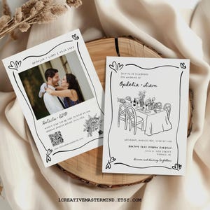 May include: Two white rectangular wedding invitation cards with black line art borders featuring hearts. One card displays a photograph of a couple, a QR code, and text. The other card features a line drawing of a table setting and event details.