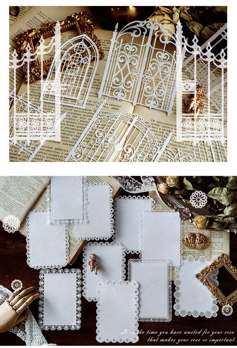 May include: A set of eight white paper cards with a delicate lace border. The cards are arranged on a brown surface with a book and other decorative items.