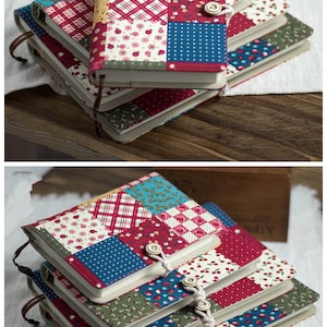 K&ouml;nnte beinhalten: Ein Stapel von drei Notizb&uuml;chern mit Patchwork-Stoffbez&uuml;gen. Die Bez&uuml;ge zeigen eine Vielzahl von Mustern, darunter rotes und wei&szlig;es Karo, blaue und wei&szlig;e Punkte und Blumenmuster. Jedes Notizbuch hat einen Knopfverschluss und einen Stoffanh&auml;nger.