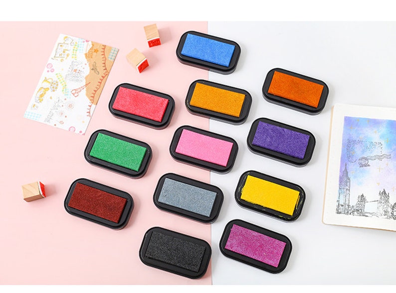 May include: A set of 10 ink pads in various colors, including red, orange, yellow, green, blue, purple, pink, gray, brown, and black. The ink pads are in individual plastic cases with a clear lid.