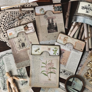 Könnte beinhalten: Ein Set aus drei Keramikbechern mit gesprenkelter, matter Oberfläche. Die Becher sind in Creme-, Hellgrau- und Dunkelgrautönen gehalten. Jeder Becher hat ein schlichtes, minimalistisches Design und einen abgerundeten Henkel.