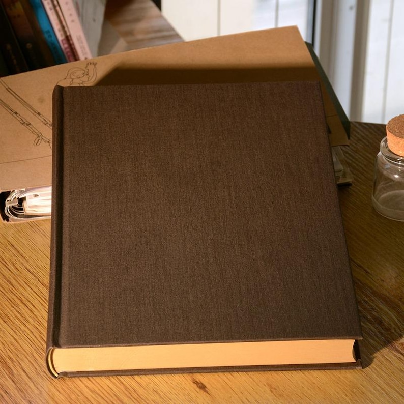 Puede incluir: Un libro de tapa dura de color marr&oacute;n oscuro con una cubierta texturizada y un lomo marr&oacute;n claro.