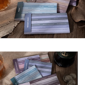 May include: A set of colorful note cards with inspirational quotes and phrases. The cards are arranged in a stack, with the top card showing the quote "One can always be kind to people they don't care about." The cards are printed on a textured paper with a subtle gradient effect.