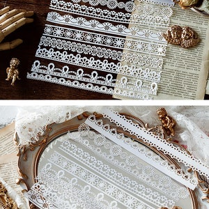 May include: A set of 10 white lace trims with various patterns, including floral, scalloped, and geometric designs. The trims are arranged in two rows on a wooden surface and a mirrored surface.
