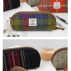 May include: A collection of semi-circular pencil cases crafted from Harris Tweed wool fabric. Each case features a zipper closure and a white rectangular label with the Harris Tweed logo and text. The patterns include multi-colored plaid and herringbone.