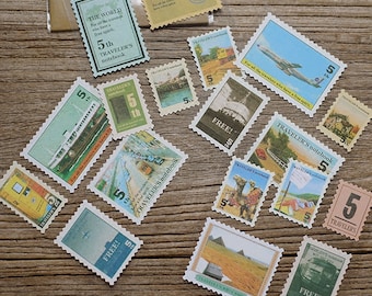 May include: A collection of vintage-style stamps featuring various travel-themed images, including airplanes, boats, camels, and cityscapes. The stamps are printed with the text "TRAVELER'S notebook" and "FREE!" in a variety of colors.