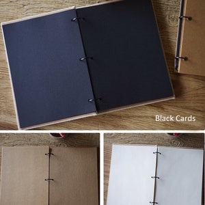 Może przedstawiać: Trzy otwarte albumy fotograficzne z r&oacute;żnokolorowymi stronami. Pierwszy album ma czarne strony, drugi ma brązowe strony z papieru kraft, a trzeci ma białe strony. Wszystkie trzy albumy mają brązową okładkę i są zszyte czarnymi k&oacute;łkami.