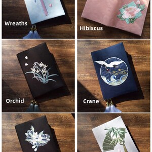 May include: Six different book covers with embroidered designs. The covers are made of a variety of fabrics, including blue, pink, black, and white. The designs include wreaths, hibiscus, orchids, cranes, pear pistils, and green bamboo.