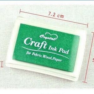 K&ouml;nnte beinhalten: Ein gr&uuml;nes Bastel-Stempelkissen in einem durchsichtigen Plastikgeh&auml;use. Das Stempelkissen ist mit "Crystal Craft Ink Pad" und "for Febric, Wood, Paper" beschriftet. Das Stempelkissen misst 7,2 cm x 5,2 cm.