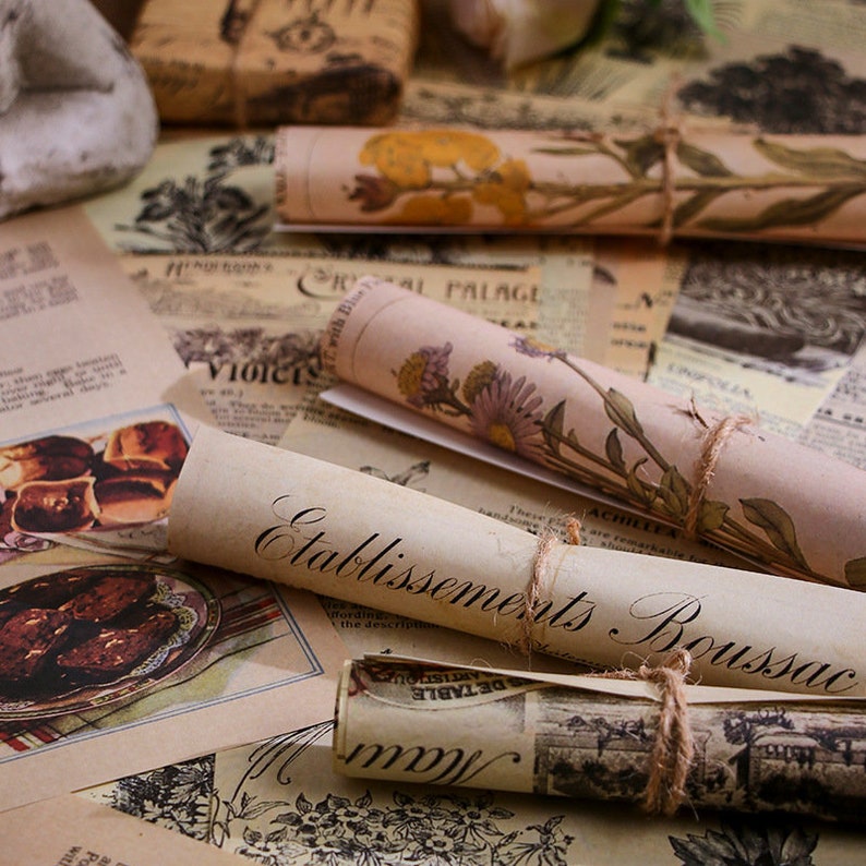 May include: Vintage style paper scraps with floral and botanical illustrations. The paper is rolled up and tied with twine. The text on the paper reads "Etablissements Boussac".