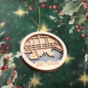 May include: A wooden Christmas ornament featuring a detailed map of Fell's Point, a neighborhood in Baltimore, Maryland. The ornament is circular and has a rustic brown finish.