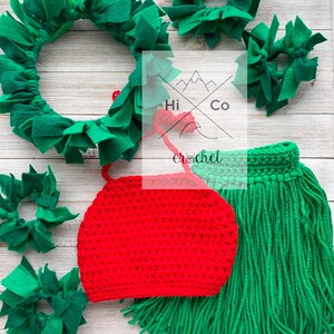 May include: A red crocheted hat with green fringe, a green felt wreath, and four smaller green felt wreaths. The text "Hi Co Crochet" is visible in the background.