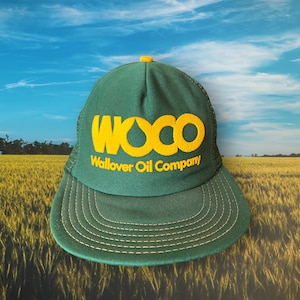 May include: A green and yellow trucker hat with the text "WOCO Wallover Oil Company" embroidered on the front.