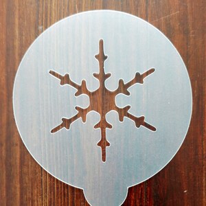 May include: A white plastic snowflake stencil for decorating cakes, cookies, or other crafts.