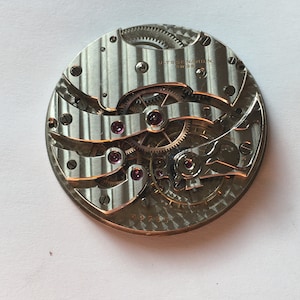 May include: A close-up of a silver watch movement with the text "ULYSSE NARDIN SWISS" printed on the face.