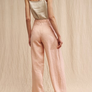 K&ouml;nnte beinhalten: Eine weite Hose in hellrosa. Die Hose hat eine hohe Taille und eine lockere Passform. Sie ist aus Leinen gefertigt und hat eine leicht strukturierte Oberfl&auml;che.