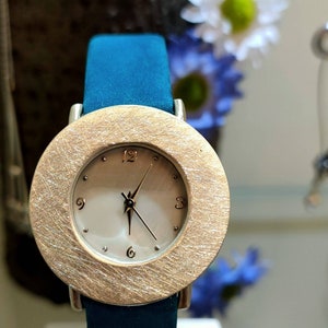 Sterling silver plain watch with mother of pearl face and suede nubuck strap and stainless steel buckle.