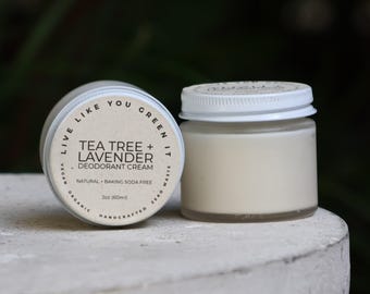 Może przedstawiać: Mały szklany słoiczek z kremowym dezodorantem w kolorze złamanej bieli z białą zakrętką. Etykieta zawiera napis: Live Like You Green It, Tea Tree + Lavender Deodorant Cream, Natural, Baking Soda Free, Vegan, Organic, Handcrafted, Zero Waste, 2oz (60ml).