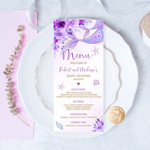 Könnte beinhalten: Eine Babyparty-Menükarte mit Meerjungfrauen-Thema. Die Speisekarte hat ein lila und lavendelfarbenes Farbschema mit floralen und Muschel-Akzenten. Die Speisekarte umfasst Vorspeisen, Hauptgerichte, eine Momosa-Bar und eine Dessertbar. Die Speisekarte befindet sich auf einem weißen Teller mit rosa Hintergrund.