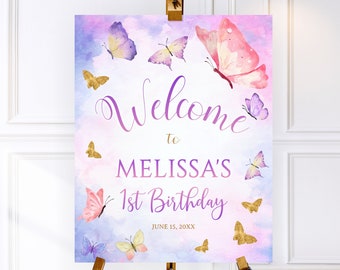 May include: Welcome to Melissa's 1st Birthday sign with a watercolour background and butterflies in shades of pink, purple, and gold. The text is in a purple script font.