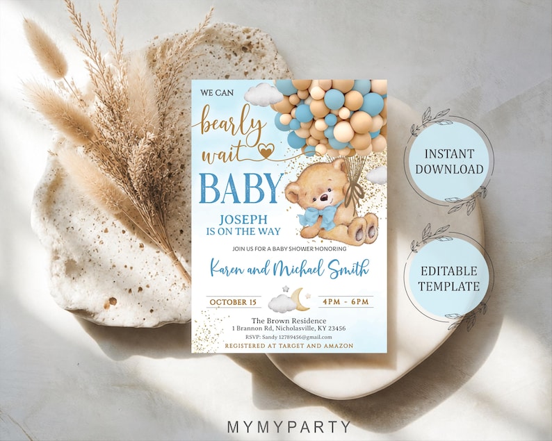 Flat lay of the printed baby shower invite next to dry pampas grass and modern boho decor elements.