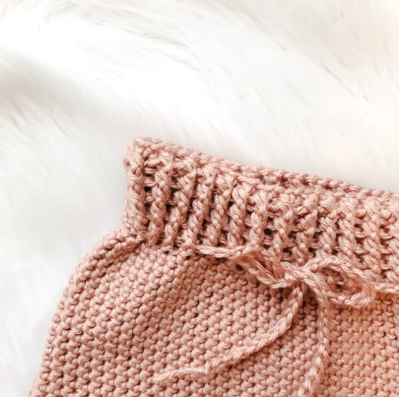 Puede incluir: Un gorro de beb&eacute; de ganchillo de color rosa suave con un cord&oacute;n de ajuste.