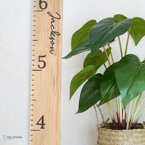 May include: A wooden growth chart with a ruler marked in inches from 4 to 6. The name "Jackson" is written in cursive on the chart.