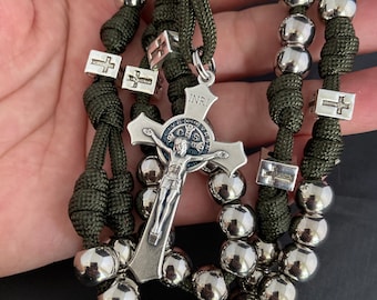 May include: A green paracord rosary with silver beads and a silver crucifix featuring the inscription "INRI".