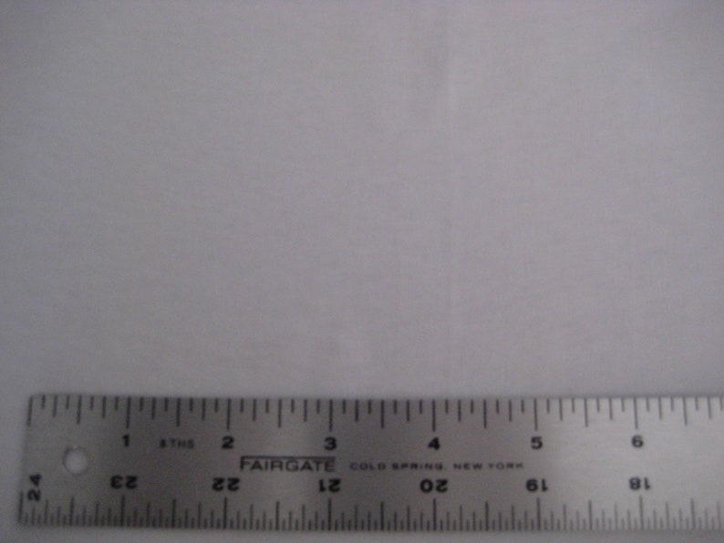 May include: A silver metal ruler with black markings. The ruler is 6 inches long and has markings for every 1/16th of an inch. The ruler is labeled "FAIRGATE COLD SPRING NEW YORK".