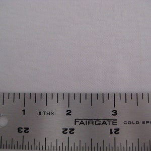 May include: A close-up of a silver metal ruler with black markings. The ruler is labeled "FAIRGATE" and "COLD SPRING, NE". The ruler is marked in inches and 8ths of an inch.