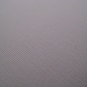 May include: Close-up of a plain, off-white fabric with a subtle woven texture.