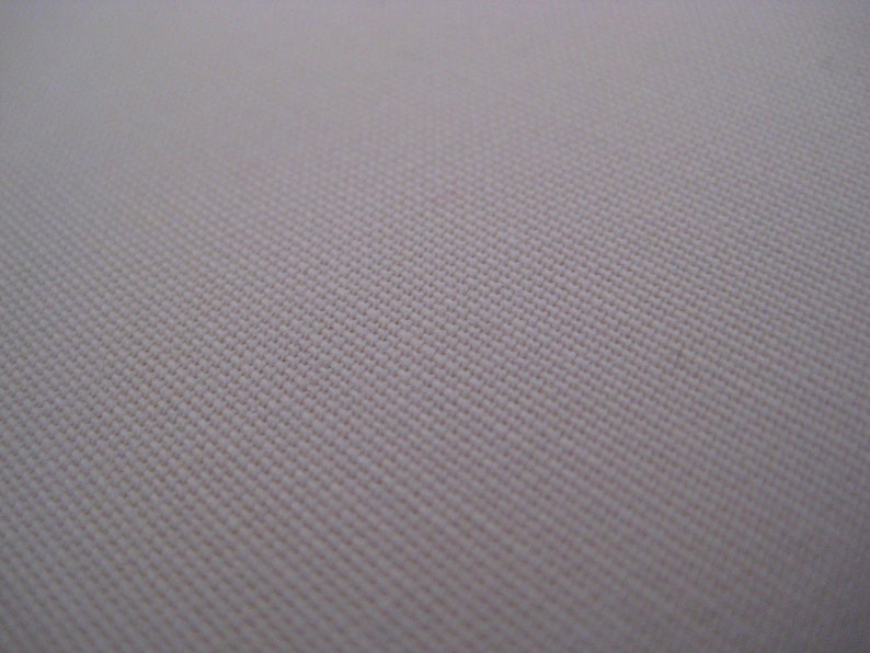 May include: Close-up of a plain, off-white fabric with a subtle woven texture.