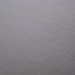 May include: Close-up of a white fabric with a textured surface.