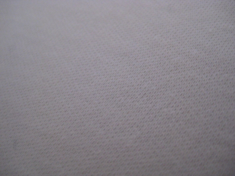 May include: Close-up of a white fabric with a textured surface.