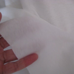 May include: Close-up of a white fabric, showing its texture and drape.
