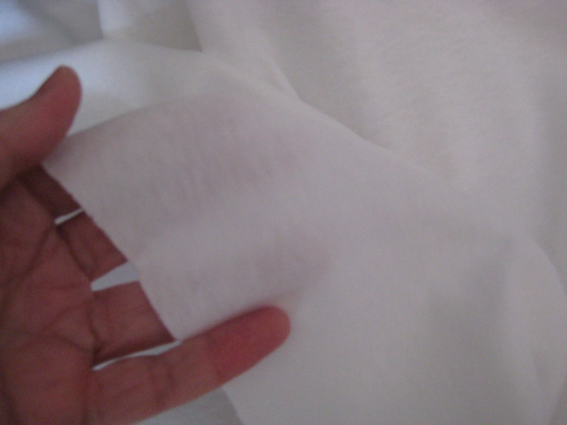 May include: Close-up of a white fabric, showing its texture and drape.