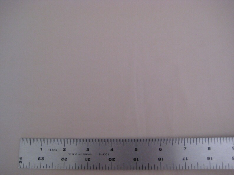 May include: A close-up of a silver ruler with black markings. The ruler is marked in inches and 16ths of an inch. The ruler is labeled "Made in U.S.A."